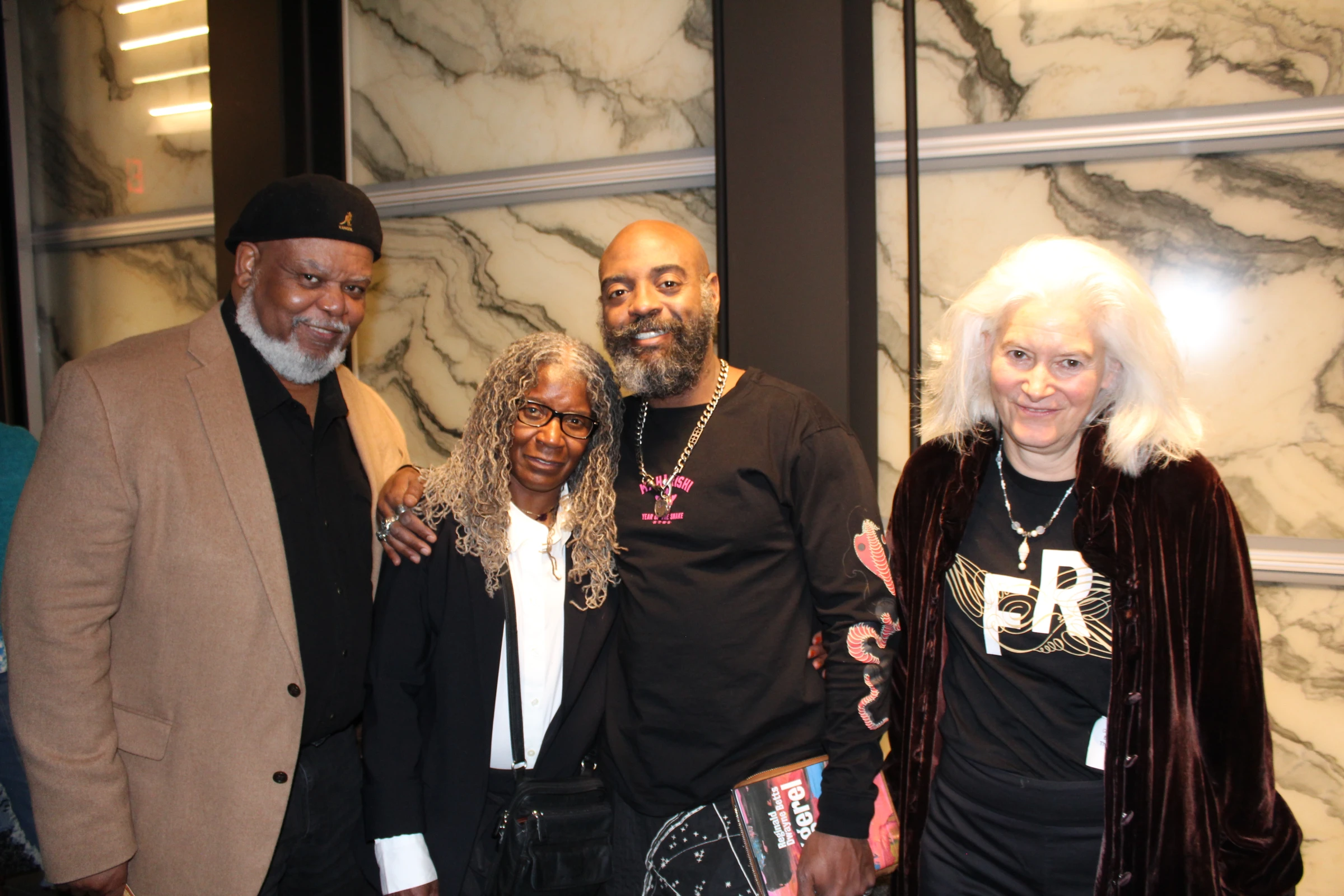 Freedom Reads Founder & CEO Reginald Dwayne Betts stands with three people, family and friends, smiling after his March Forth performance at the Perelman Performing Arts Center in New York City this month.