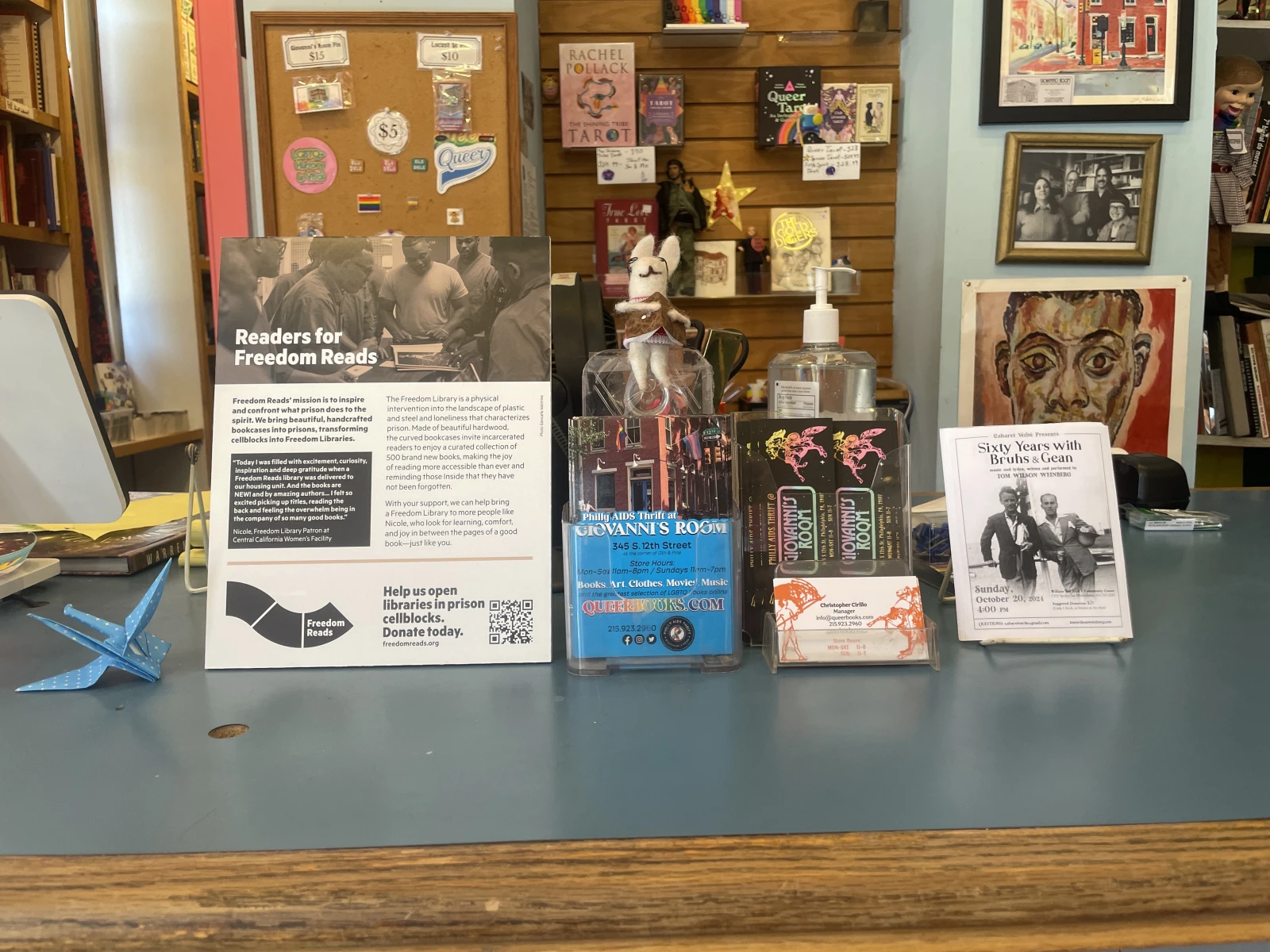 A Readers for Freedom Reads poster on a bookstore counter next to other flyers.