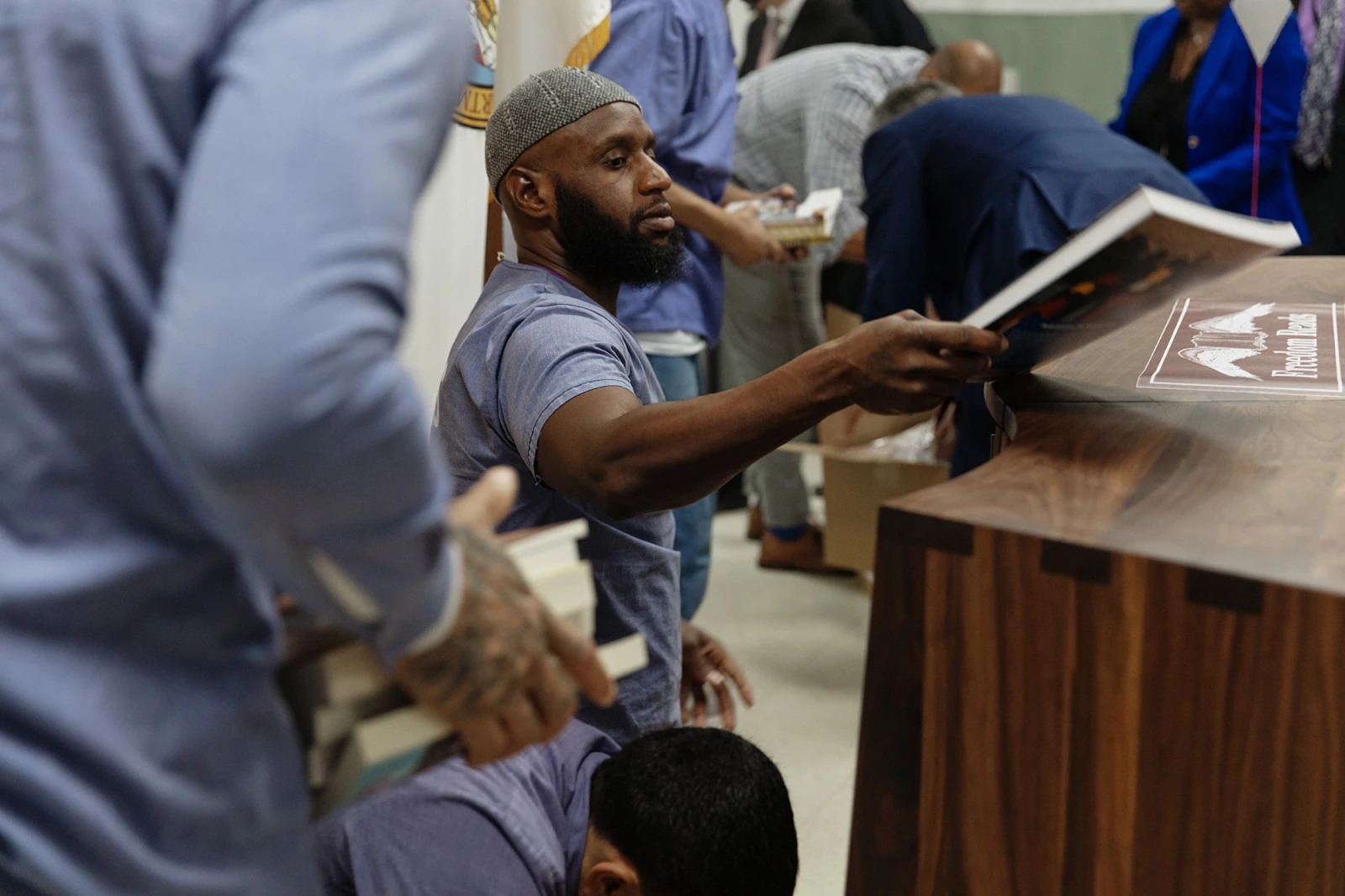 Library Patrons carry stacks of books over to one of the brand new Freedom Libraries at Dorsey Run Correctional Facility in Maryland during an opening.