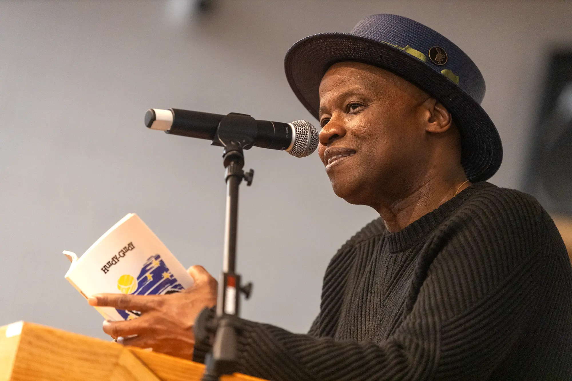 Poet Randall Horton speaks into a microphone, reading his poetry aloud for poetry lovers at Carl Robinson Correctional Institution in Connecticut.